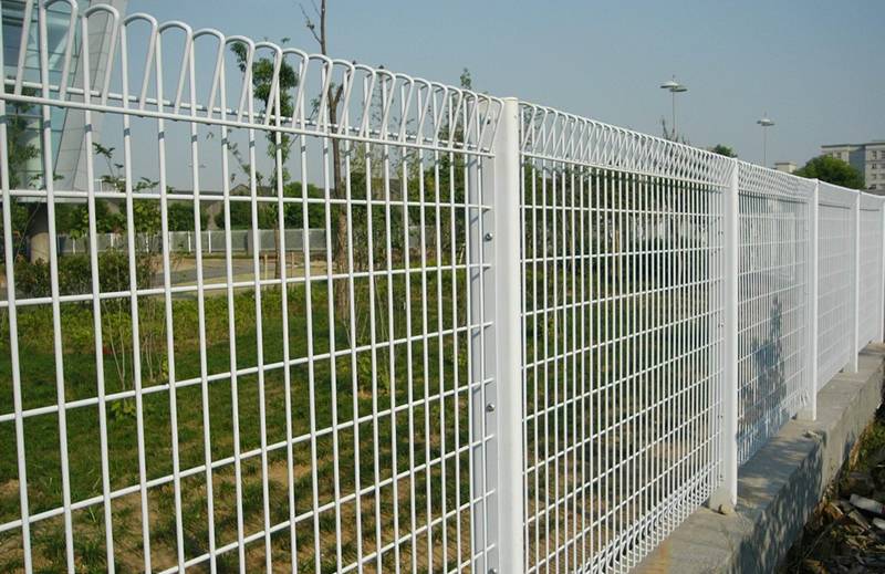 White vinyl-coated roll top fencing for a business area.