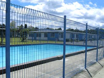 Blue pool fence manufactured according to law.