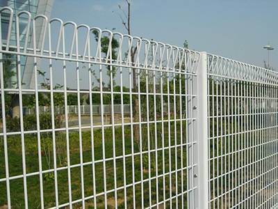 White vinyl-coated roll top fencing for a business area.