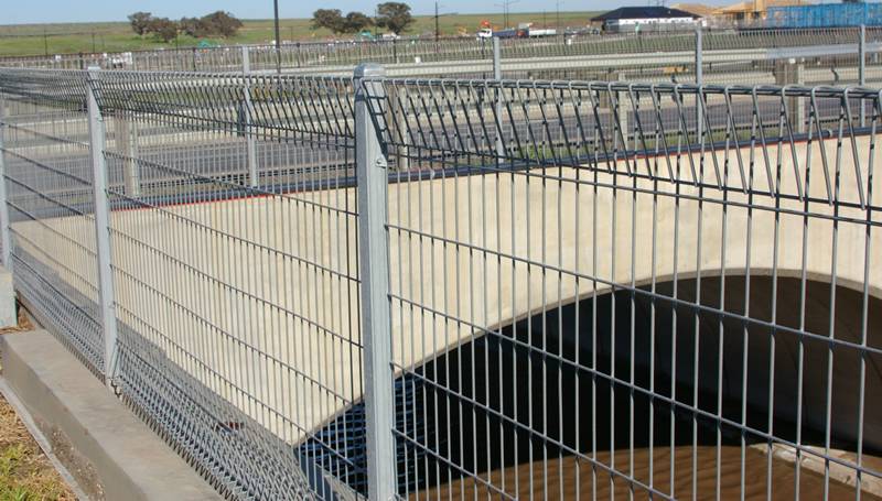 Galvanized roll top welded wire fence along bridge resist accidents.