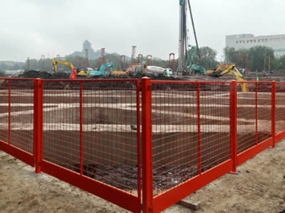 This is red welded wire fence in construction site.