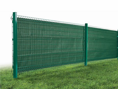 There is a welded wire fence with windbreak netting in the grassland.